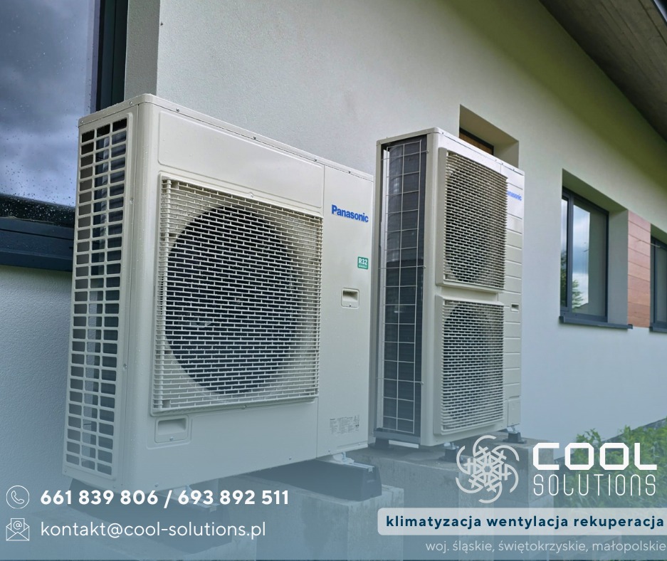 Dwa klimatyzatory Panasonic zamontowane na zewnątrz budynku. Jeden większy, drugi mniejszy, oba w jasnej obudowie. Widoczne okna budynku w tle.