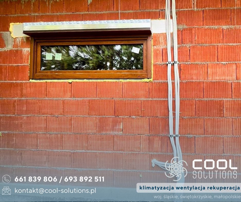 Montaż okna w surowym murze z widocznymi przewodami instalacji wentylacyjnej. Widoczne logo firmy COOL SOLUTIONS z danymi kontaktowymi.