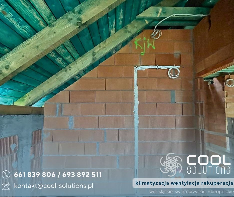 Instalacja przewodów wentylacyjnych na ceglanej ścianie poddasza z drewnianą konstrukcją dachu. Widoczne elementy systemu wentylacji.