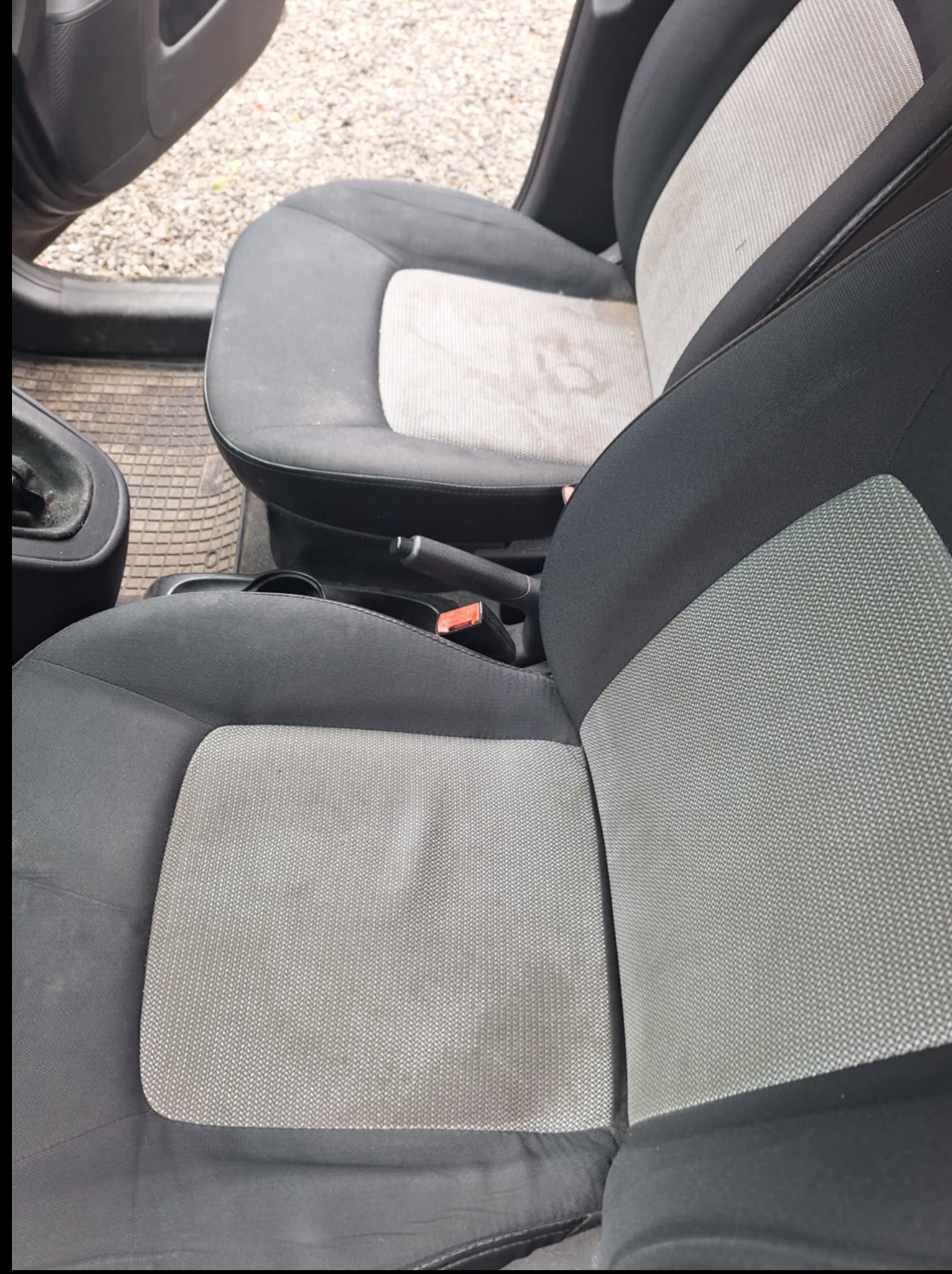 Tapicerka fotela samochodowego z widocznymi plamami i zabrudzeniami, ukazująca potrzebę profesjonalnego czyszczenia.