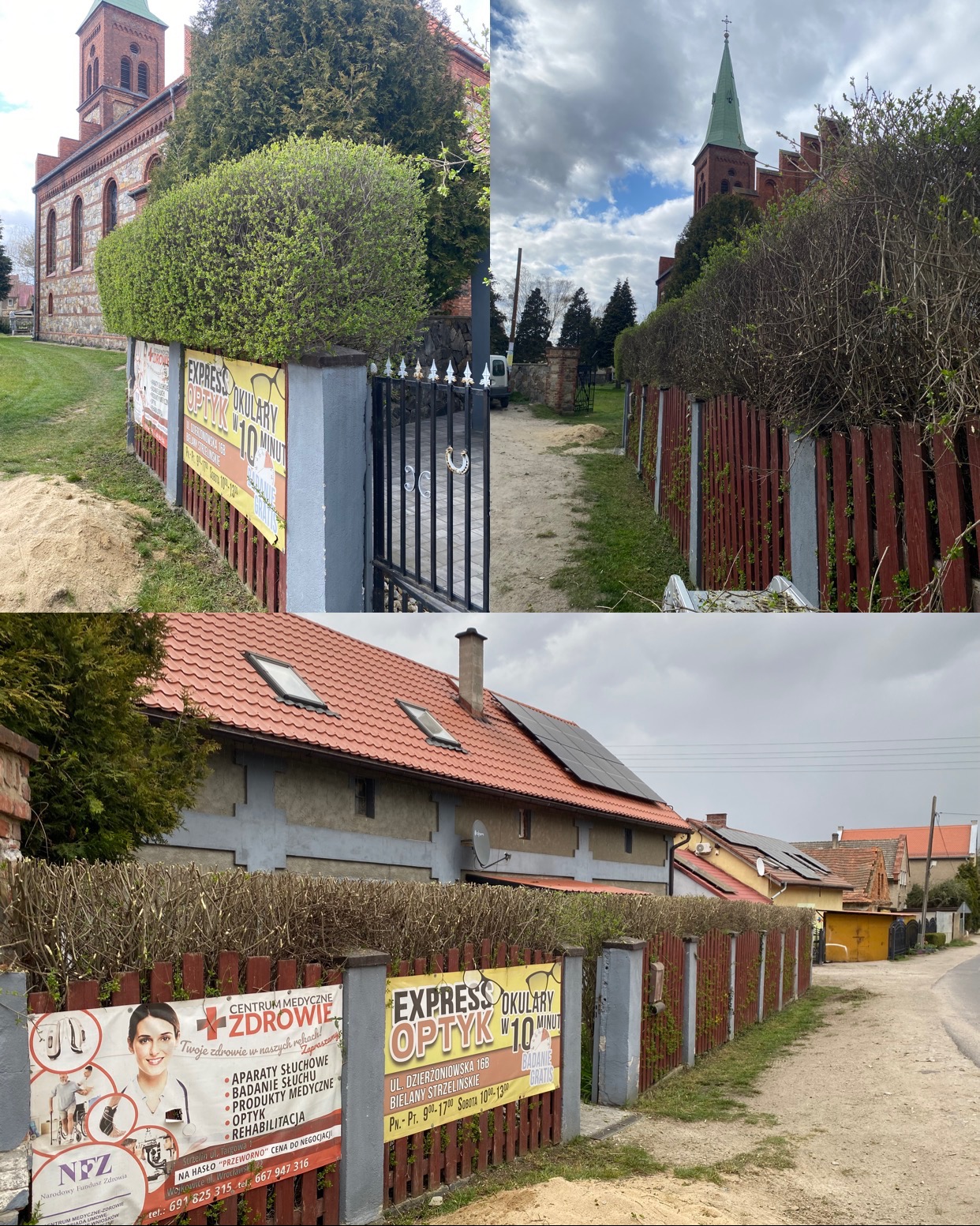 Formowane krzewy wzdłuż ogrodzenia z reklamami, kościół w tle. Widok na posesję z budynkami i drogą.  Przycięte żywopłoty, zielona roślinność.