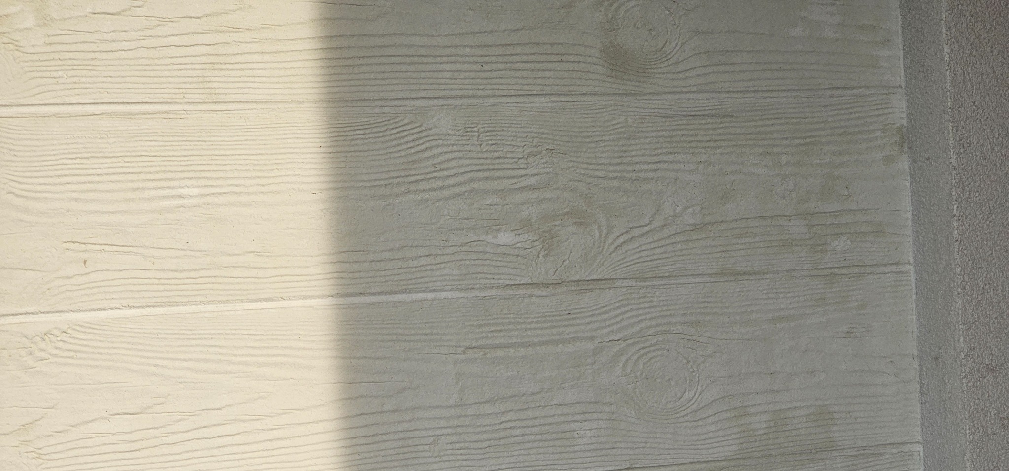 Faktura elewacyjna imitująca drewno, w odcieniach beżu i szarości, z wyraźnym cieniem, Dobrzyca. Efektowna dekoracja ściany zewnętrznej.