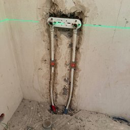 M&D Remont4everyone Mykola Petruniv - Montaż instalacji wodnej w łazience, widoczne rury i laserowy poziom na ścianie w trakcie prac. Surowy stan, przygotowanie do dalszych prac wykończeniowych.