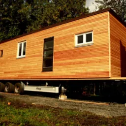 Mobilny dom z modułów drewniano-słomianych zbudowany na naczepie od tira.