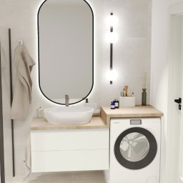 Projektowanie wnętrz Anna Żyjewska-Bas - Nowoczesna łazienka z owalnym lustrem podświetlanym LED, białą umywalką nablatową i pralką w zabudowie. Minimalistyczny design z akcentami beżu.