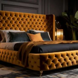 Musztardowe, pikowane łóżko z wysokim wezgłowiem, na tle ciemnej ściany i roślin. Złote lampki nocne i kryształowy żyrandol dodają elegancji wnętrzu.