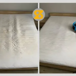 Zdjęcie materaca przed i po czyszczeniu. Po prawej stronie materac jest czysty, suszony wentylatorem. Widoczne różnice w kolorze i plamach.