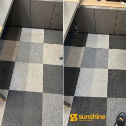Sunshine Cleaning Service Viacheslav Hordiienko - Dywan w szachownicę przed i po czyszczeniu, widoczne różnice w odcieniach szarości, biurowe otoczenie, logo firmy w prawym dolnym rogu.