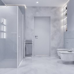 To Oni Projektują - Minimalistyczna łazienka w odcieniach szarości z kabiną prysznicową typu walk-in, podświetlanymi półkami i wiszącą toaletą. Nowoczesny design z betonową teksturą ścian.