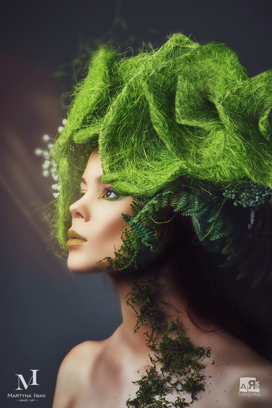 Profil kobiety z artystycznym makijażem i zielonym nakryciem głowy z mchu i paproci, subtelne oświetlenie, ciemne tło. Efekt sesji wizerunkowej.