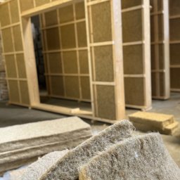 Hemptech Solutions Sp. z o. o . - Wnętrze hali z elementami konstrukcji ścian wypełnionych izolacją z włókien naturalnych. Na pierwszym planie sprasowane bele izolacyjne.