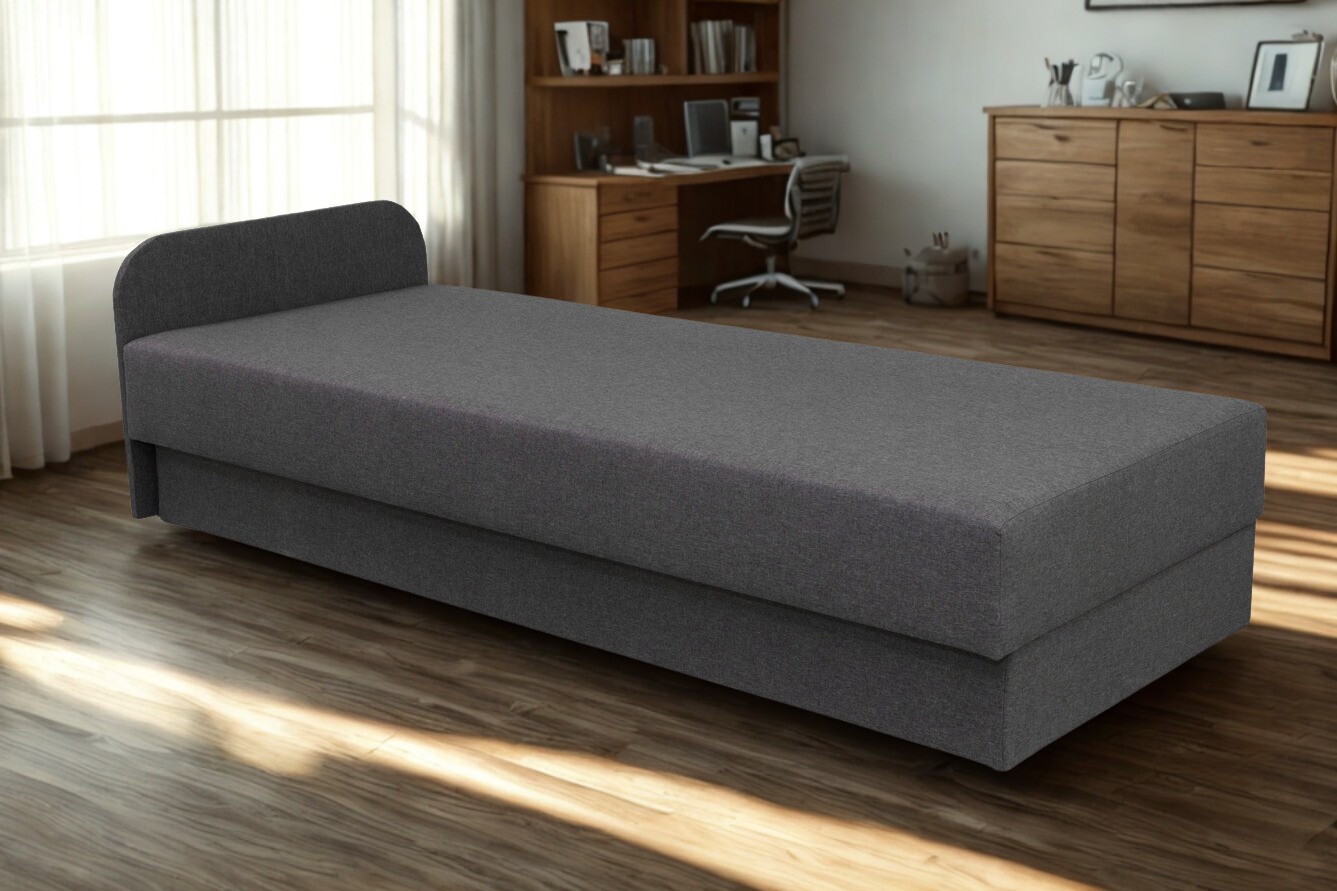 Szary tapczan z zagłówkiem w nowoczesnym pokoju, drewniana podłoga i biurko w tle. Minimalistyczny design, miękkie światło, idealny do relaksu.