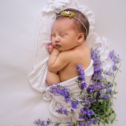 Świeże kwiaty w tle, by podkreślić wyjątkowy czas narodzin.

