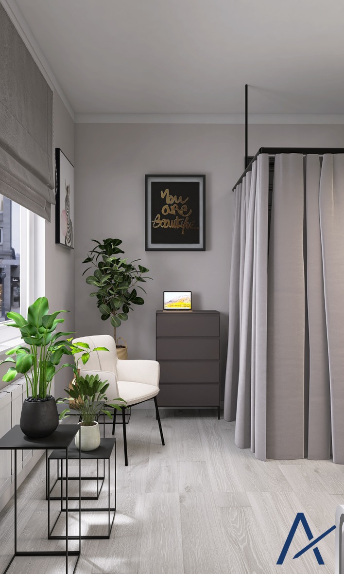 Jasne wnętrze pokoju z roślinami doniczkowymi, białym krzesłem i szarą komodą. Na ścianie grafika w ramce. Zasłony oddzielają przestrzeń. Podłoga z paneli w odcieniach szarości.