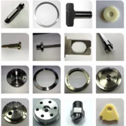 Kolekcja precyzyjnie wykonanych detali CNC z różnych materiałów: metal, tworzywo. Widoczne śruby, pierścienie, dysze i inne elementy o wysokiej dokładności obróbki.