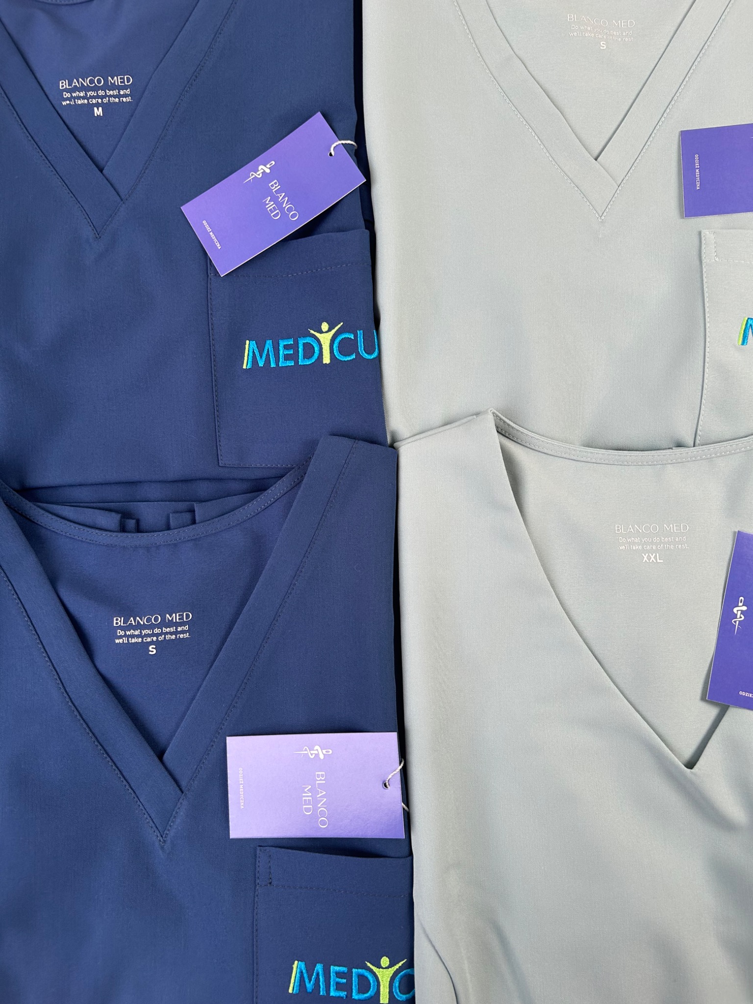 Komplet odzieży medycznej Blanco Med w odcieniach szarości i granatu z logo Medicus. Szycie na miarę w Świerzynach. Widoczne rozmiary M, S i XXL.
