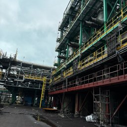 TOPREM SPÓŁKA Z OGRANICZONĄ ODPOWIEDZIALNOŚCIĄ - Kompleksowa konstrukcja przemysłowa z rurociągami, schodami i platformami, po czyszczeniu. Widoczne ślady po czyszczeniu.