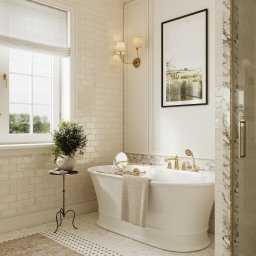 Mala & Co. Malwina Wilczek - Elegancka łazienka w odcieniach beżu z wolnostojącą wanną, złotą armaturą i marmurowym akcentem kabiny prysznicowej. Na ścianie obraz w czarnej ramie.