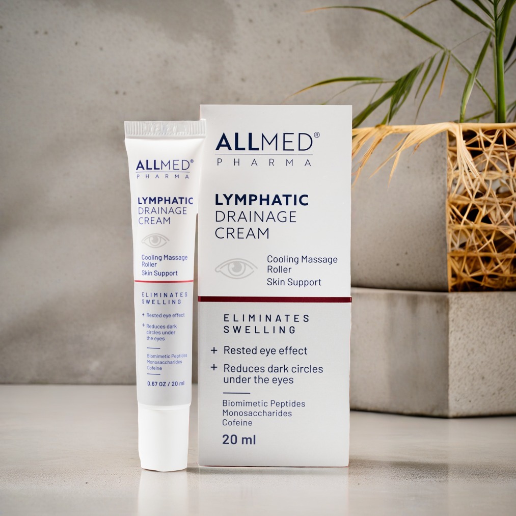Krem Allmed Lymphatic Drainage Cream w tubce i pudełku na tle betonowej ściany i rośliny. Produkt do pielęgnacji skóry, redukujący obrzęki i cienie pod oczami.
