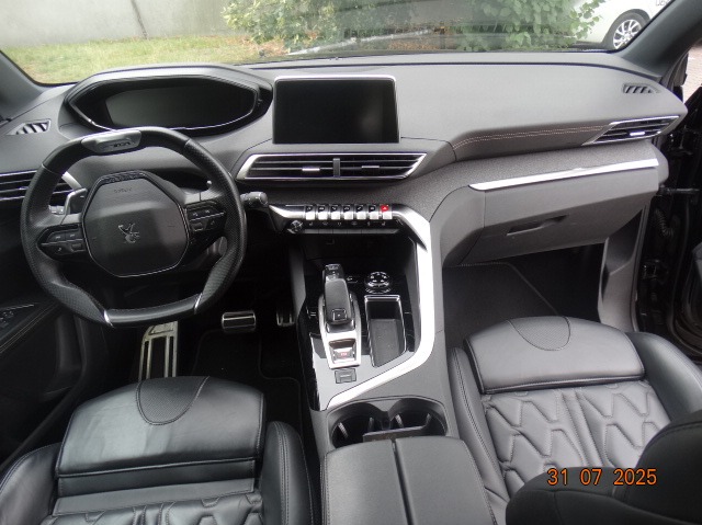 Wnętrze samochodu Peugeot 3008 z czarną skórzaną tapicerką, widok na deskę rozdzielczą, kierownicę i fotel kierowcy. Automat.