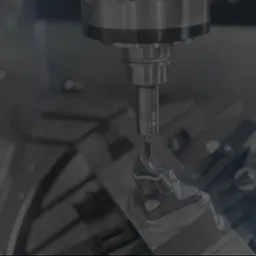 Precyzyjna obróbka metalu na obrabiarce CNC, detal w uchwycie, wiertło w trakcie pracy, ciemne tło, delikatne oświetlenie, widoczne narzędzia.