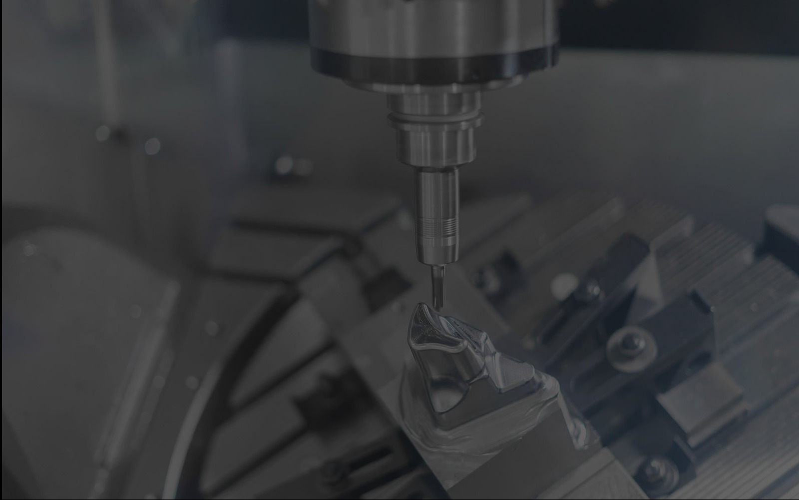 Precyzyjna obróbka metalu na obrabiarce CNC, detal w uchwycie, wiertło w trakcie pracy, ciemne tło, delikatne oświetlenie, widoczne narzędzia.