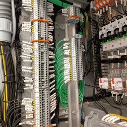 VIKTORISERVIS Stanisław Bohodukh - Rozdzielnica elektryczna z precyzyjnie oznaczonymi przewodami i listwami zaciskowymi, widoczne kable w kolorach zielonym, czarnym i żółtym, z bliska.