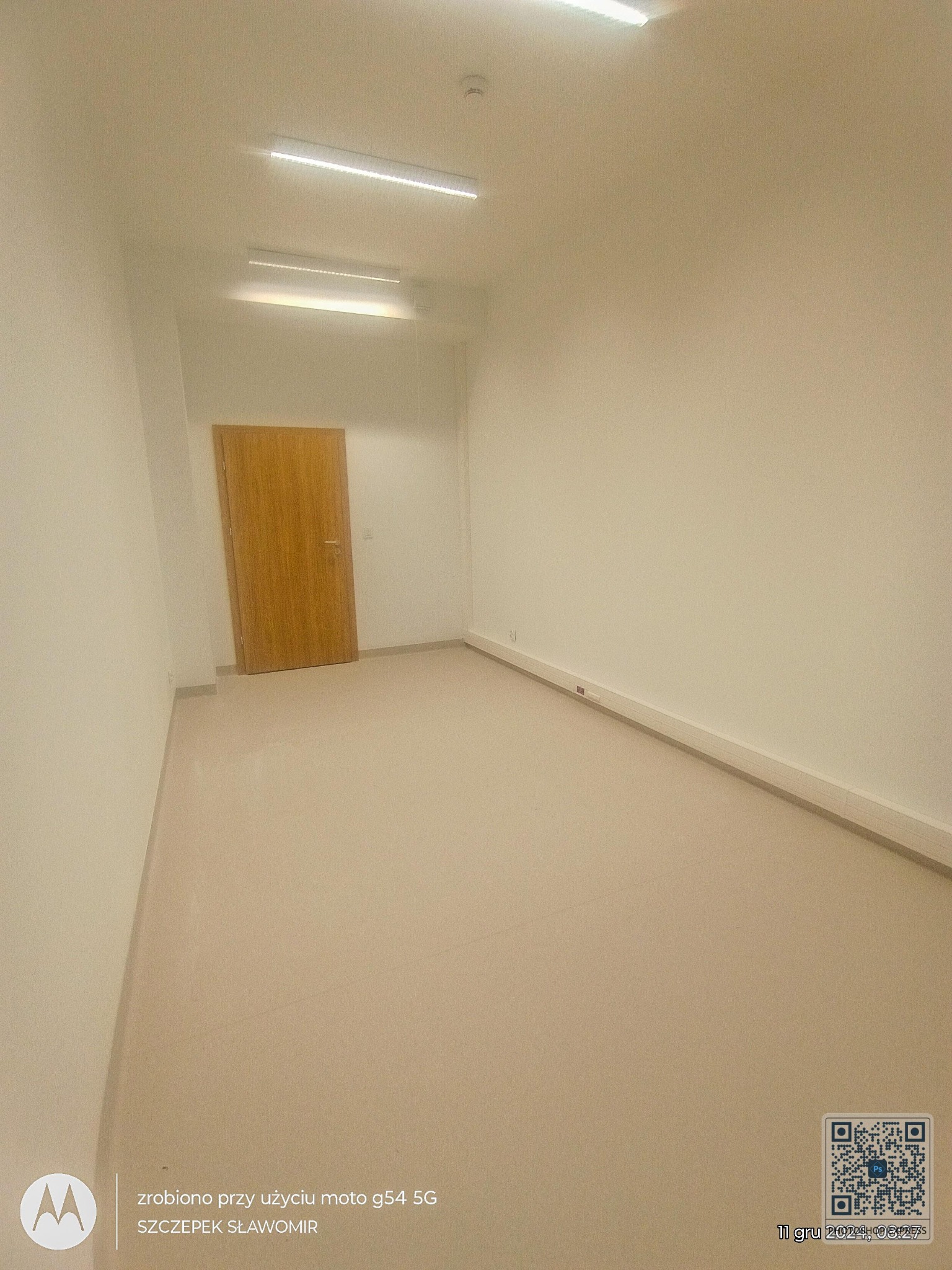 Puste, jasne wnętrze po remoncie: beżowe ściany, podłoga i drewniane drzwi. Widoczne listwy przypodłogowe i oświetlenie LED. Minimalistyczny design, gotowe do aranżacji.