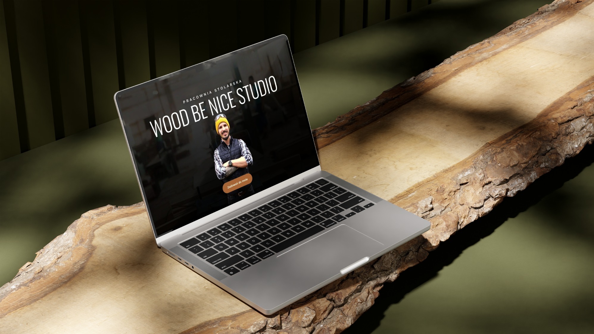 Laptop prezentuje stronę 'Wood Be Nice Studio' na tle surowego drewna i zieleni. Ukazuje nowoczesny design i profesjonalizm stolarskiej pracowni.