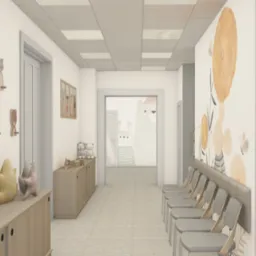 Wnętrze poczekalni z motywami dziecięcymi: drewniane wieszaki, obrazki na ścianach, wygodne krzesła. Jasne, neutralne kolory tworzą przyjazną atmosferę.