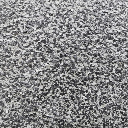Szara posadzka żywiczna z drobnymi płatkami, zbliżenie na fakturę. Realizacja posadzki przemysłowej z żywicy epoksydowej, szara kolorystyka.