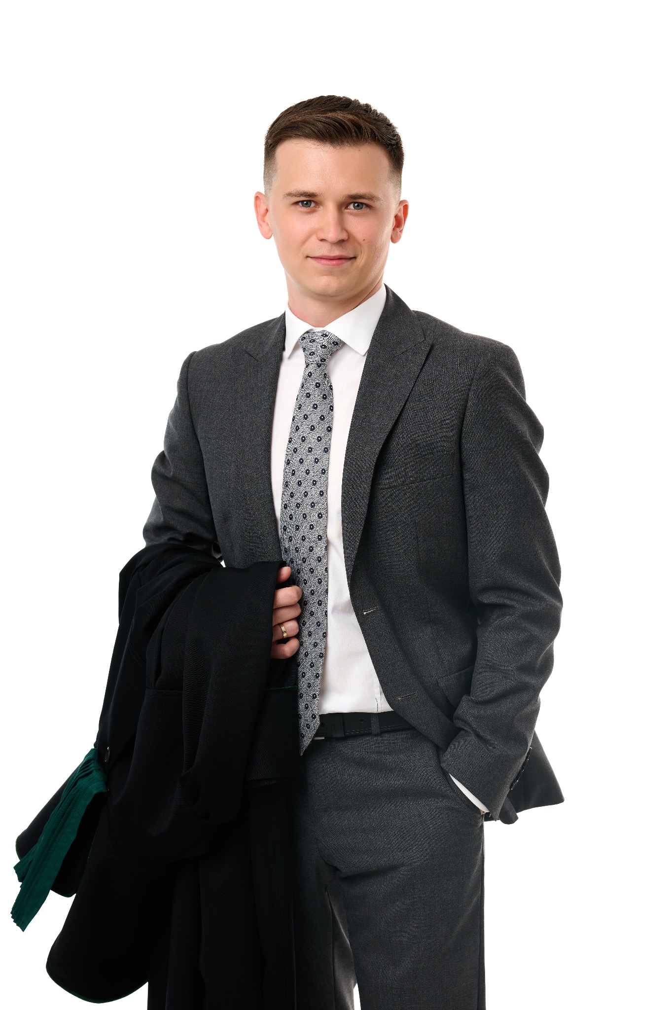 Uśmiechnięty prawnik w szarym garniturze, trzymający togę z zielonymi żabotami na białym tle. Profesjonalny wizerunek adwokata.