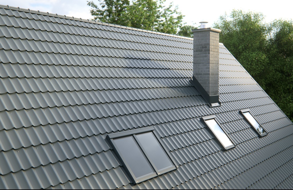 Szary dach z dachówki ceramicznej z trzema oknami dachowymi i kominem z cegły, widok z góry na tle zieleni, równomierne oświetlenie.