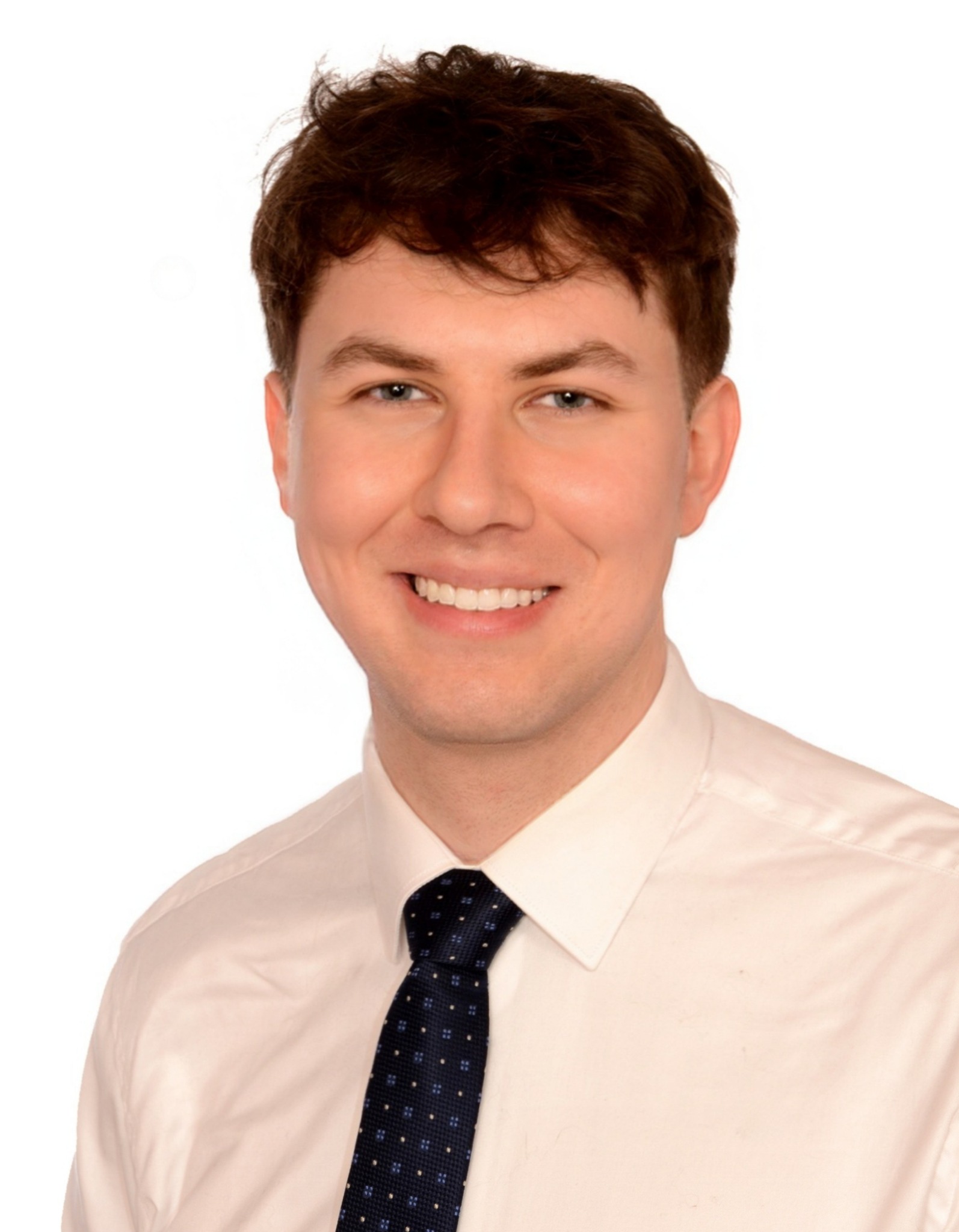 Portret uśmiechniętego mężczyzny w białej koszuli i krawacie, na jasnym tle. Zdjęcie profilowe psychologa lub psychoterapeuty, z widocznym profesjonalnym wizerunkiem.