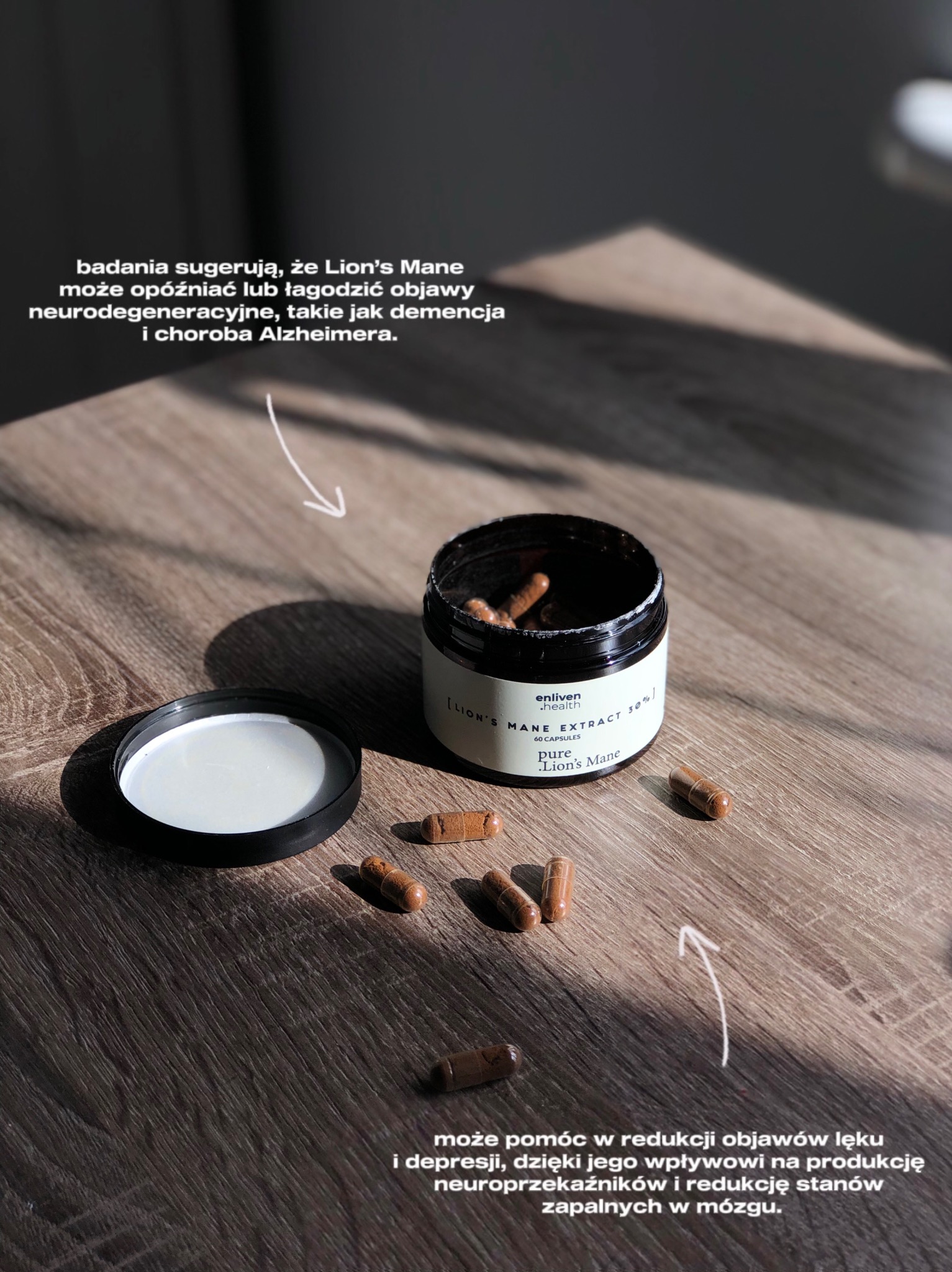 Zdjęcie suplementu diety Enliven.health Lion's Mane w czarnym opakowaniu na drewnianym stole, kapsułki rozsypane wokół. Jasne oświetlenie, widoczne napisy informacyjne.