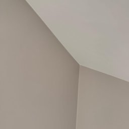 Robert Potoczny - Pomieszczenie po malowaniu: gładkie ściany w odcieniach beżu i bieli, widoczne połączenie ściany z sufitem pod kątem, minimalistyczny kadr.