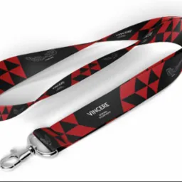 Smycz z karabińczykiem, czarno-czerwona w geometryczne wzory i logo 'Vincere Boxing Equipment', leży na białym tle, prezentacja produktu.