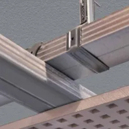 Metalowy stelaż sufitu podwieszanego z widoczną konstrukcją nośną i płytami akustycznymi o regularnym wzorze perforacji w jasnym odcieniu.