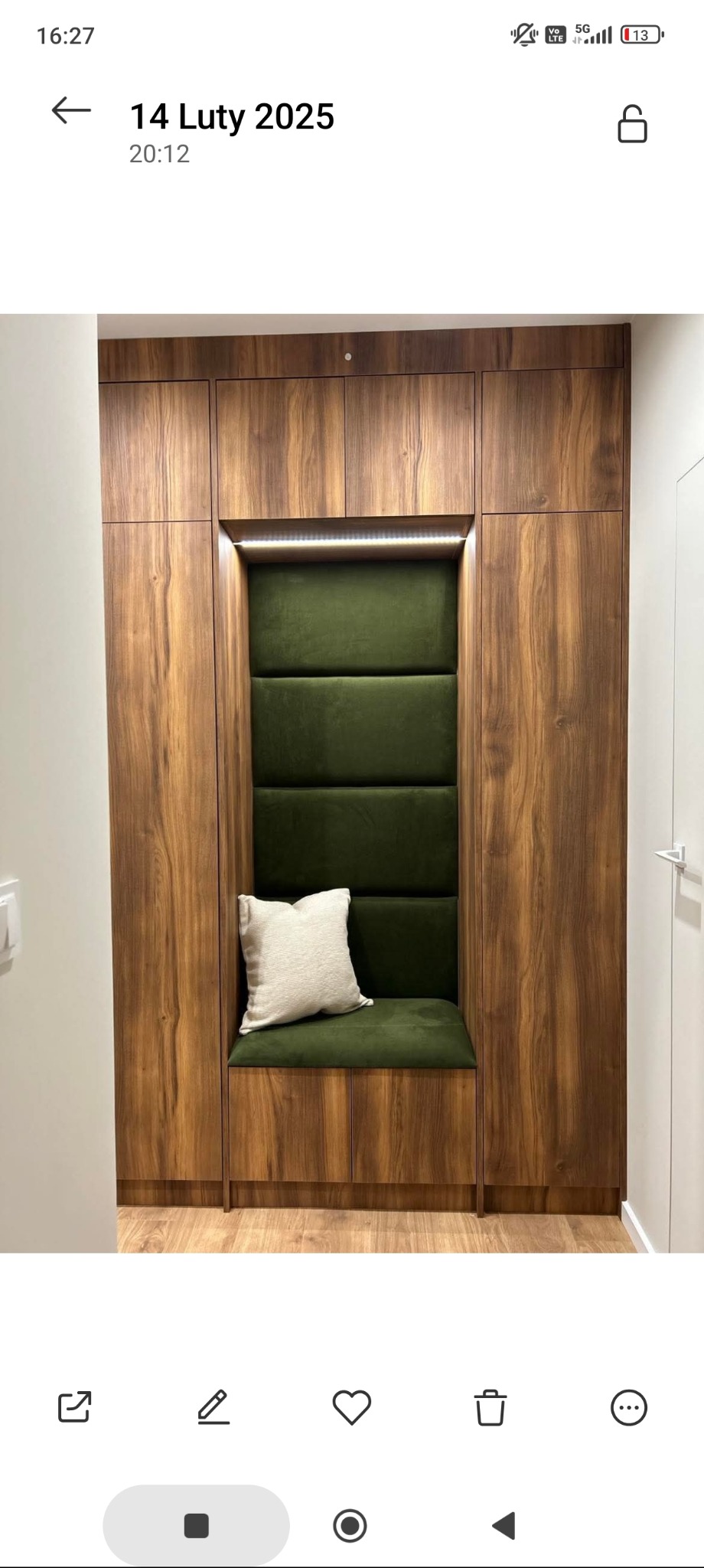 Wnęka z siedziskiem i tapicerowanym panelem w odcieniach zieleni, wbudowana w drewnianą szafę. Na siedzisku beżowa poduszka. Oświetlenie LED w górnej części wnęki.