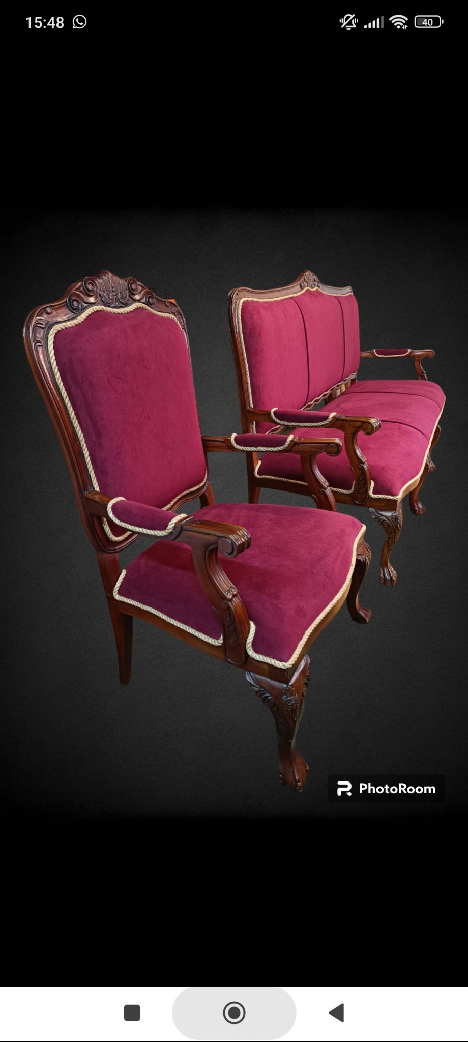 Komplet bordowych mebli tapicerowanych w stylu retro: fotel z rzeźbionymi nogami i kanapa, wykończone sznurem. Elegancki design na ciemnym tle.