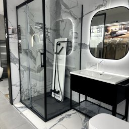 All-Chemik - płytki, armatura - Nowoczesna łazienka: kabina prysznicowa z czarną ramą, umywalka z podświetlanym lustrem i toaleta na tle marmurowych płytek podłogowych i ściennych.