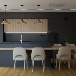 Studio - Nowoczesna, ciemna kuchnia z drewnianymi akcentami i złotą armaturą. Widoczne krzesła w jasnej tapicerce, designerskie lampy i minimalistyczny styl wykończenia.