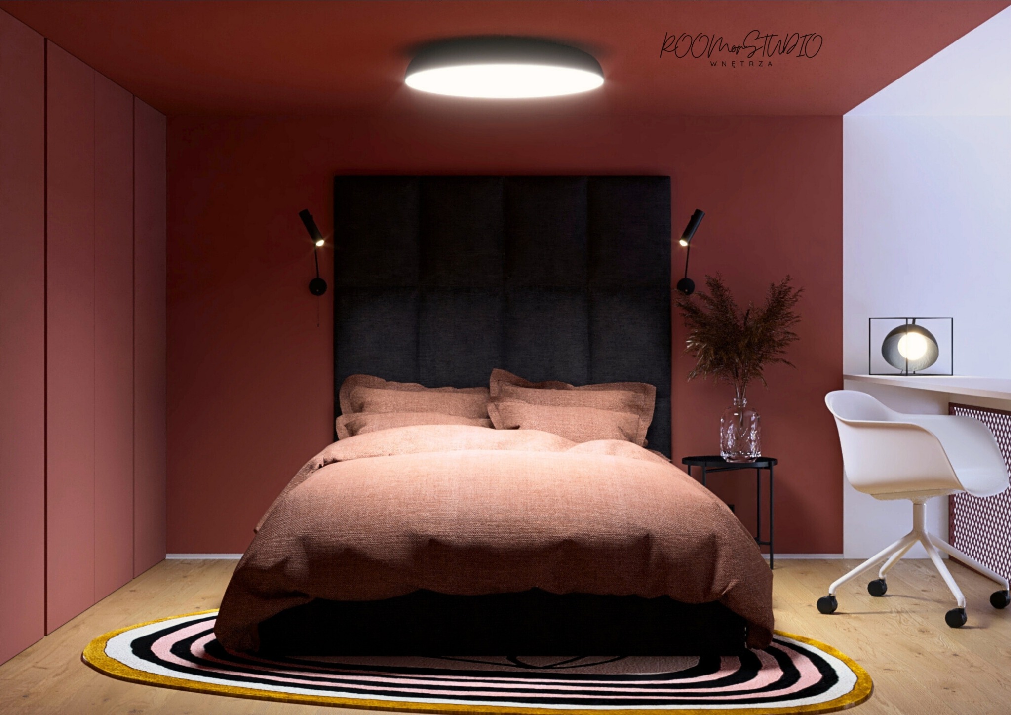 Stylowa sypialnia w odcieniach terakoty z łóżkiem, czarnym zagłówkiem i okrągłym dywanem. Minimalistyczne oświetlenie i biurko z krzesłem dopełniają aranżację.