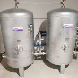 KOVALINSTAL JACEK KOWALIK - Dwa srebrne zbiorniki hydroforowe WIMEST ZCS/495/6 z manometrami i instalacją hydrauliczną na jasnej podłodze, w pomieszczeniu z białymi ścianami.