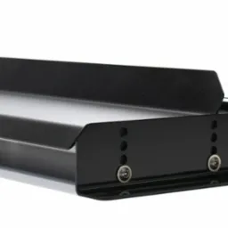 Czarna, metalowa konstrukcja z otworami i śrubami, widoczna z perspektywy. Element wykonany precyzyjnie, o gładkiej powierzchni i wyraźnych detalach.