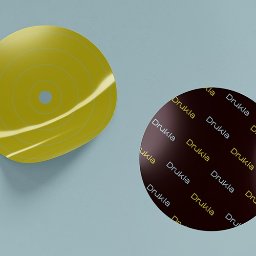 DRUKARNIA BARTOSZ DĄBROWSKI - Dwie okrągłe naklejki: żółta z koncentrycznymi okręgami i brązowa z powtarzającym się napisem 'Drukla' na jasnoniebieskim tle.