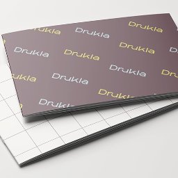 DRUKARNIA BARTOSZ DĄBROWSKI - Dwa katalogi/foldery z powtarzającym się wzorem 'Drukla' w kolorach żółtym i szarym, leżące na białym tle. Widoczne krawędzie i grzbiet.