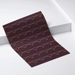 DRUKARNIA BARTOSZ DĄBROWSKI - Brązowa kartka papieru z powtarzalnym wzorem łuków w kolorze złotym i białym, leżąca na białym tle. Układ ukośny, widoczne załamania papieru.