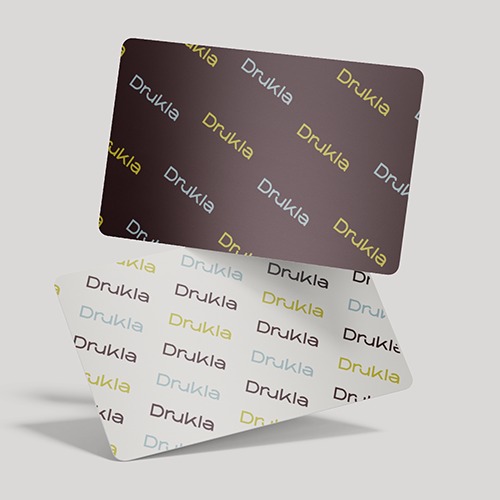 Dwie wizytówki z zaokrąglonymi rogami, ułożone jedna na drugiej, z powtarzającym się wzorem nazwy firmy w różnych kolorach na białym i brązowym tle.