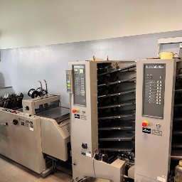 Drukarnia DRUKLANET Przemysław Dąbrowski - Profesjonalna linia introligatorska Horizon SPF-20 i MC-80 w szarej kolorystyce. Widoczne panele sterowania i podajniki. Całość w jasnym, industrialnym wnętrzu drukarni.